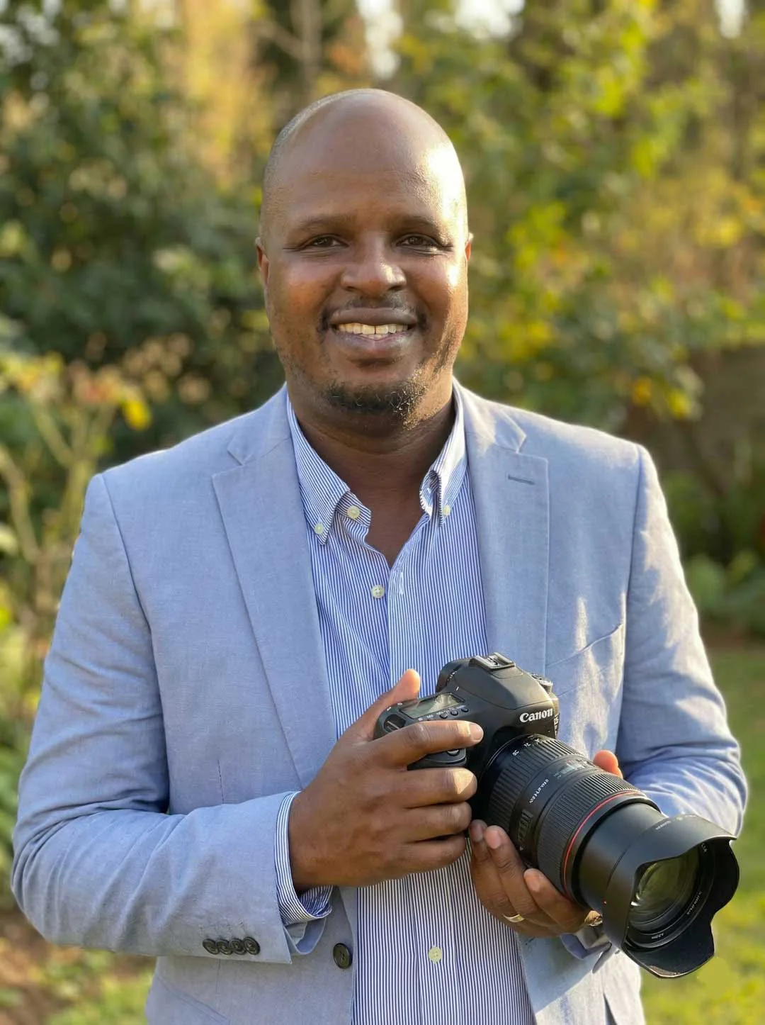 Miami Editorial Wedding Photographer Woody Henry, editorial bridal and wedding photographer and founder of Miami Bridal Photos, outdoors in golden light holding a camera